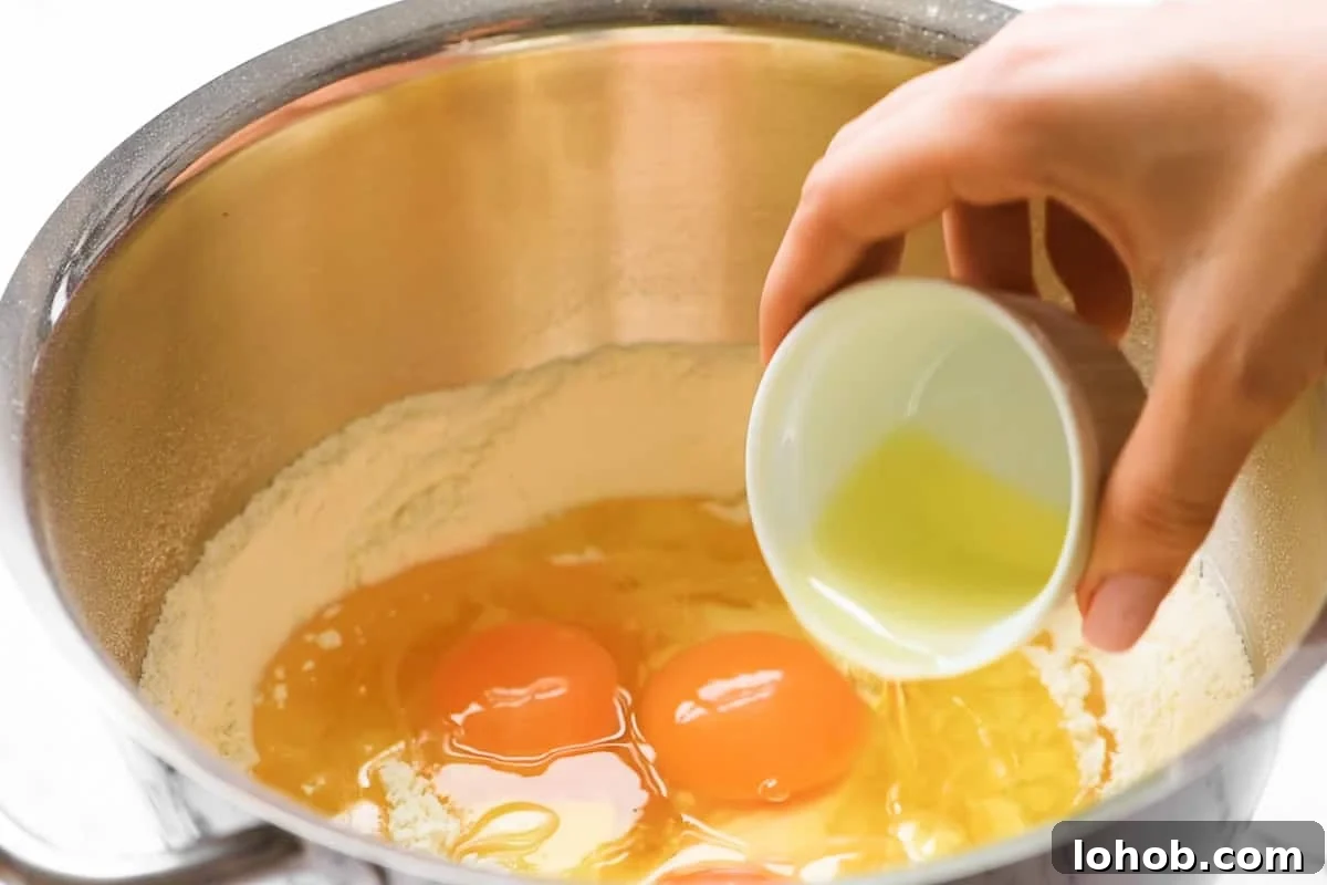 adding ingredients to bowl to make homemade challah bread.