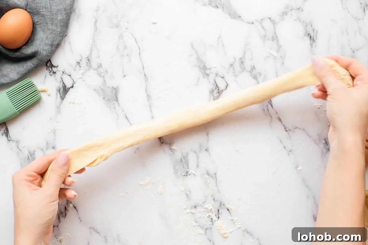 stretching a piece of homemade challah bread dough.