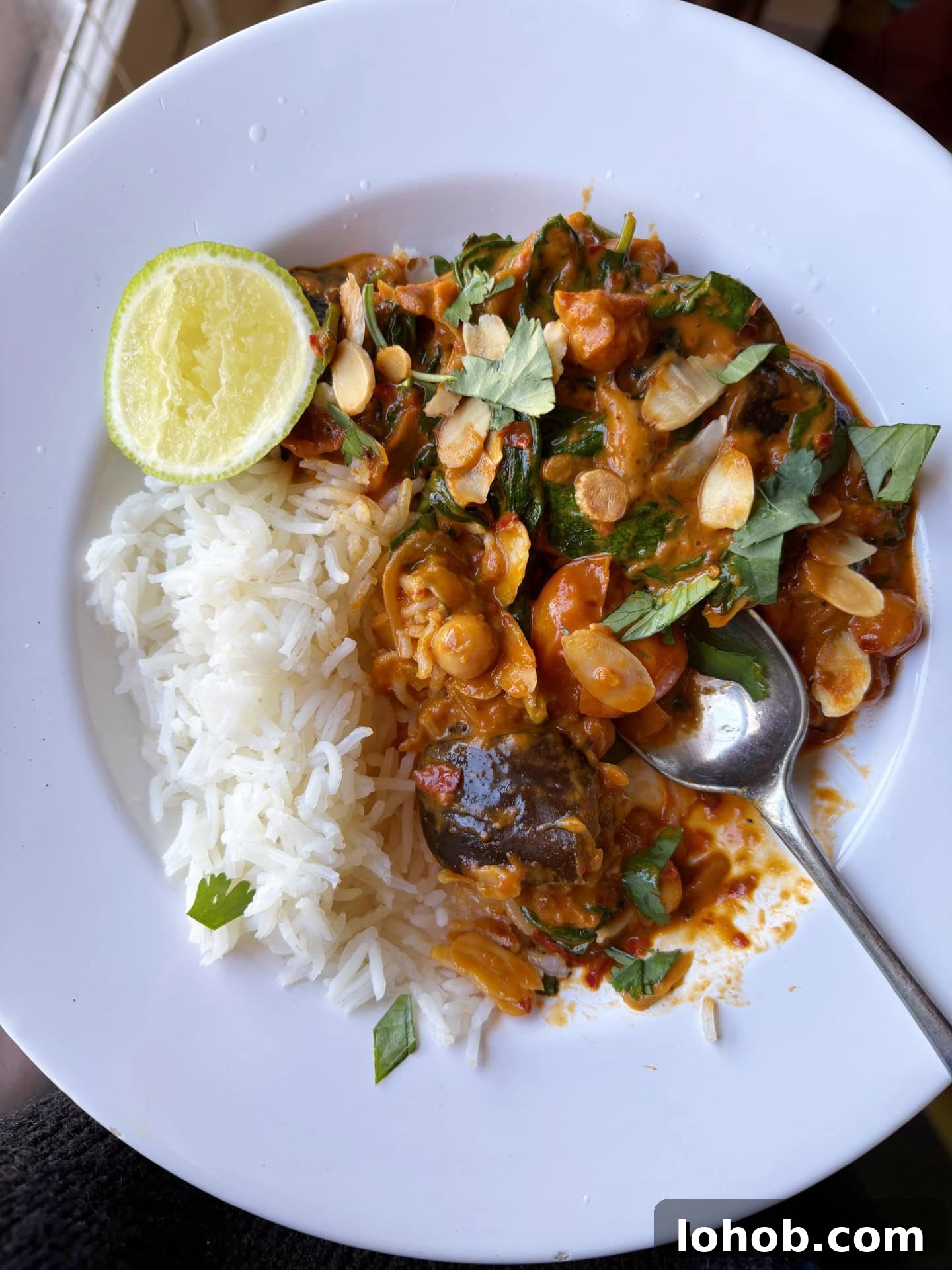 aubergine curry with rice and a wedge of lime. 