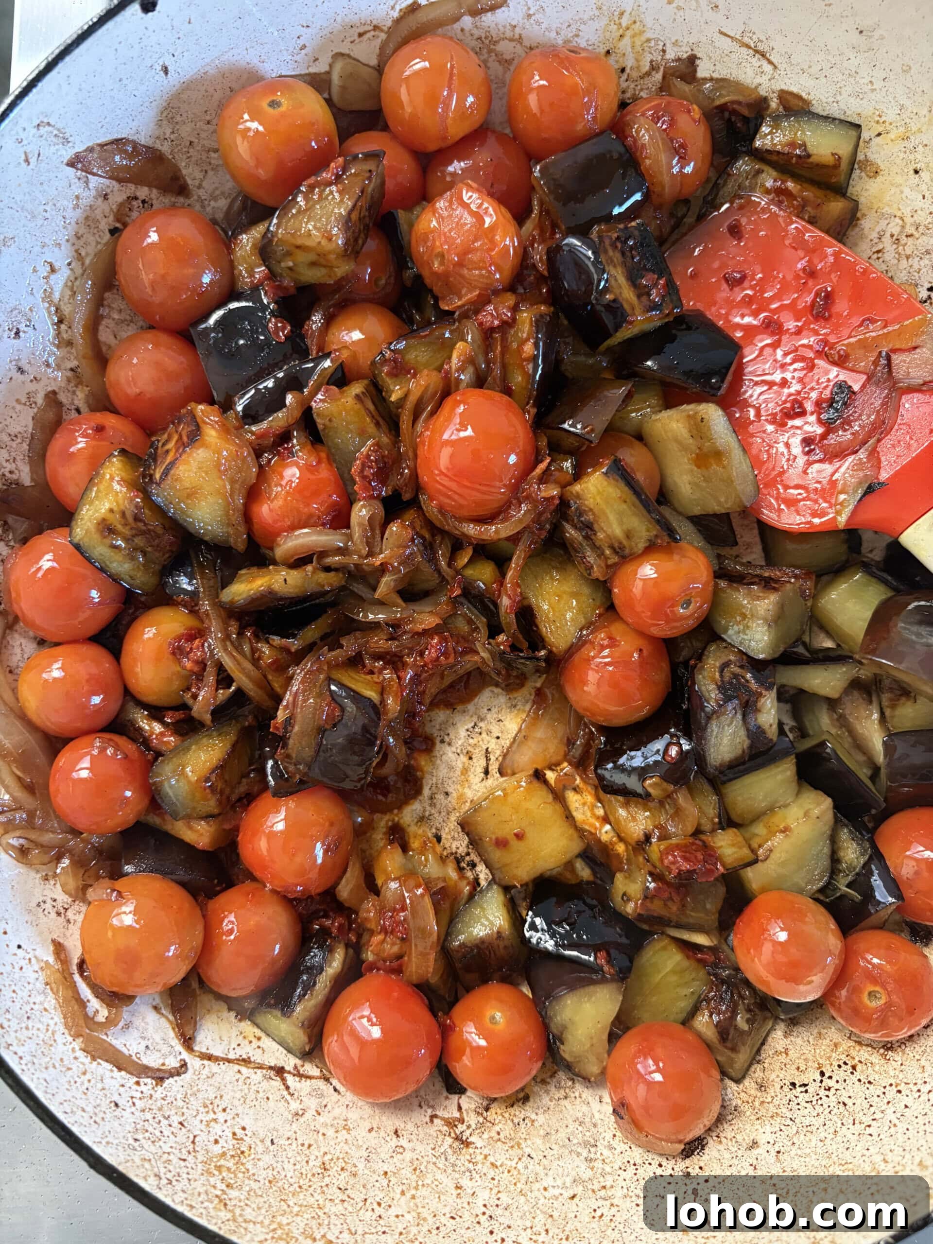 adding aubergine back to the pan.