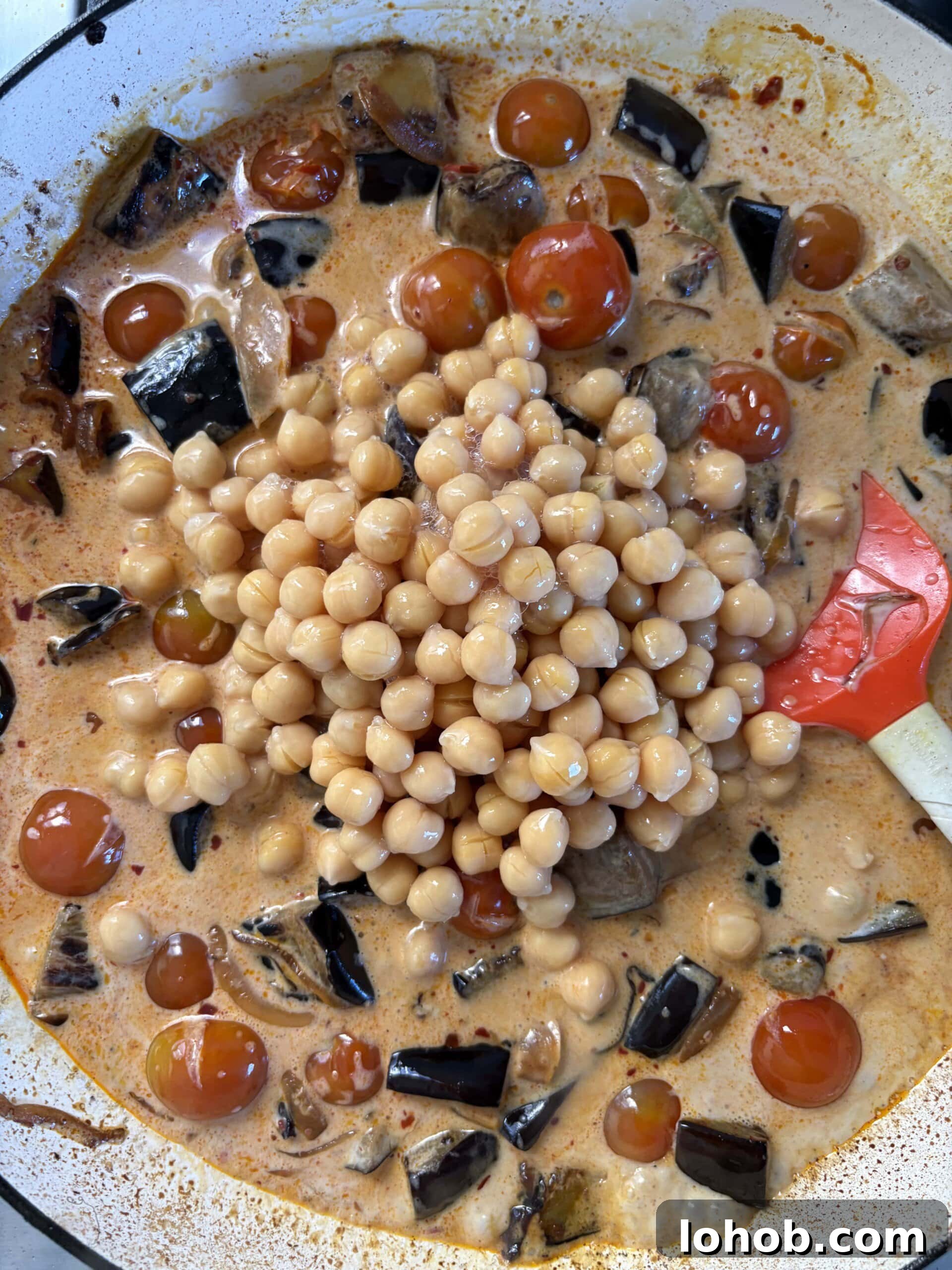 adding chickpeas to the aubergine curry.