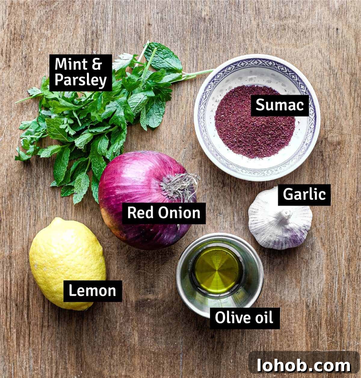 The ingredients for Sumac Onions: Red onion, sumac, garlic, lemon, olive oil, parsley and mint.