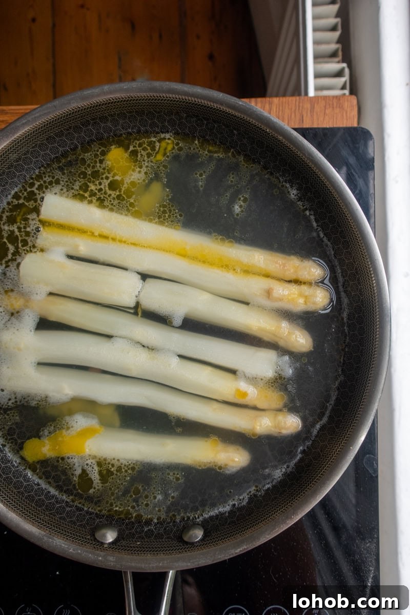 White asparagus cooking in a pan
