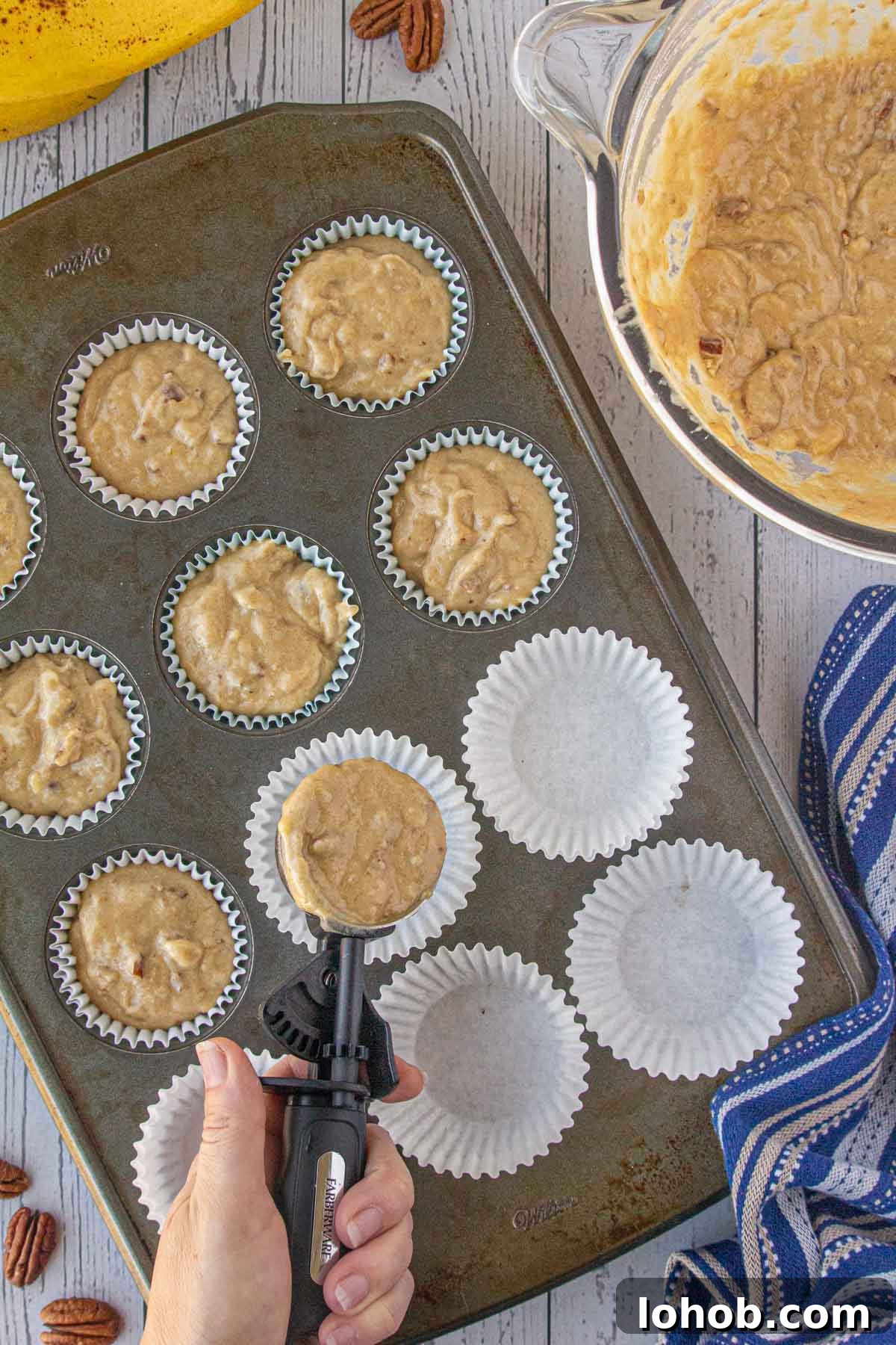 Portioning the brown butter banana pecan muffin batter into a muffin tin.