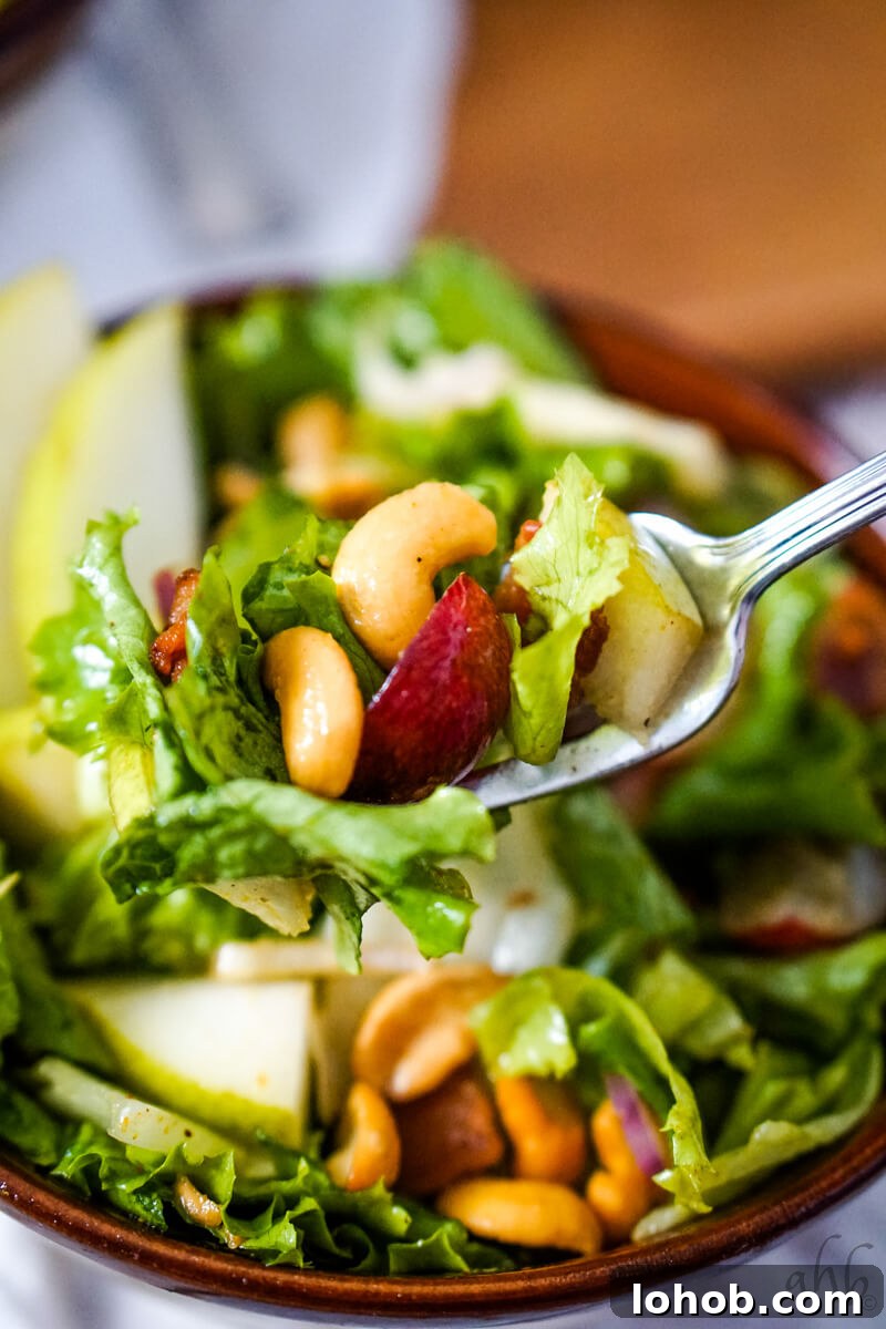 Crunchy Cashew Salad with Lime-Ginger Dressing 4 A forkful of the Cashew Nut Salad is taken from the brown bowl.