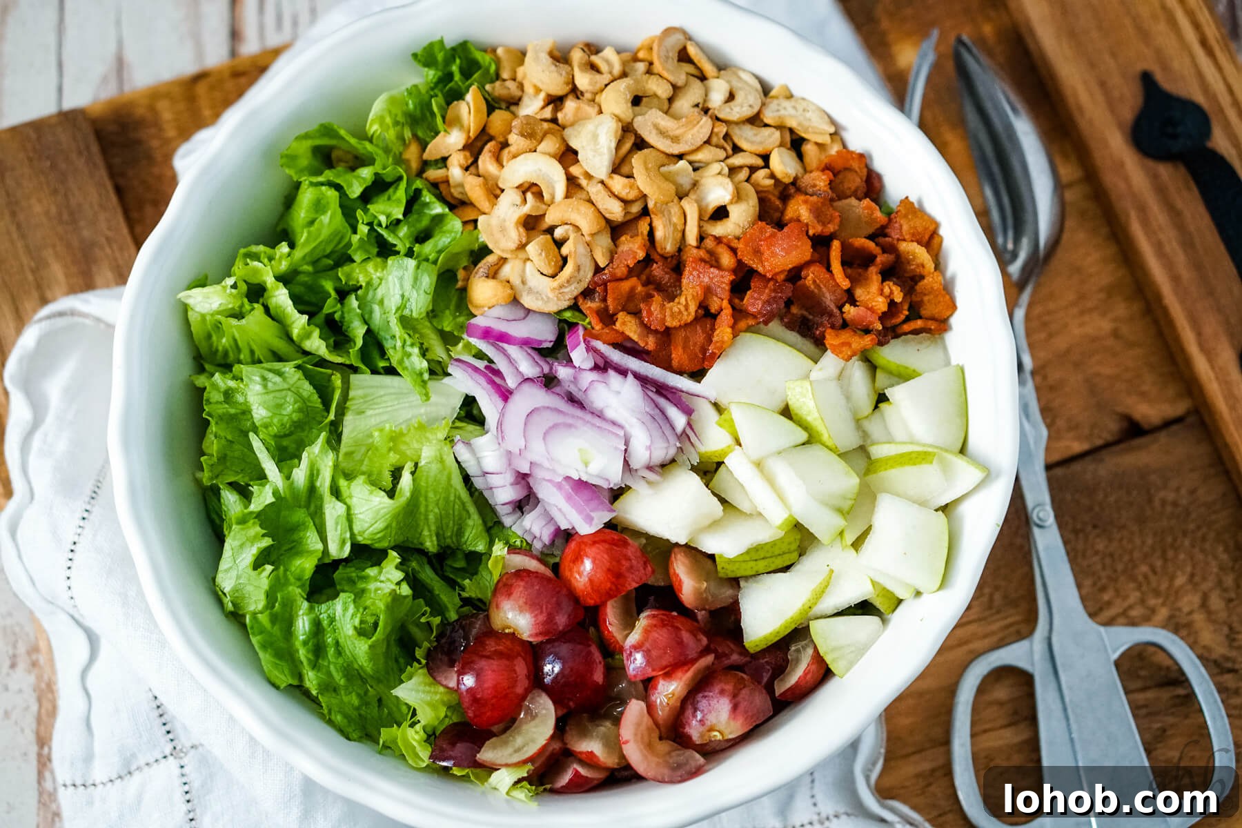 Crunchy Cashew Salad with Lime-Ginger Dressing 7 The ingredients are added to the large white bowl.