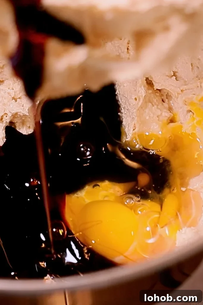 adding egg, molasses, and vanilla to butter and sugar