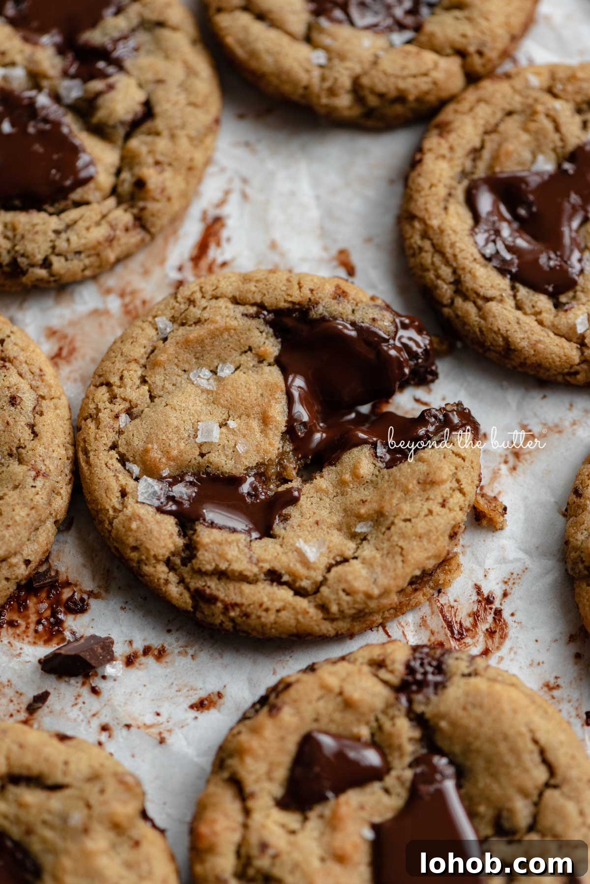 Small batch gluten-free peanut butter chocolate chunk cookies on a parchment paper lined baking sheet | © Beyond the Butter®