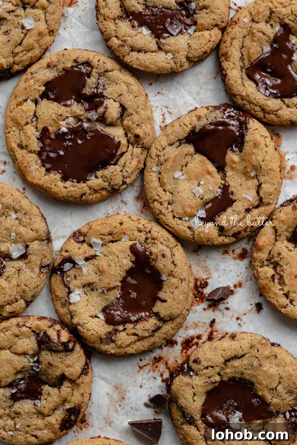 Small batch gluten-free peanut butter chocolate chunk cookies on a parchment paper lined baking sheet | © Beyond the Butter®