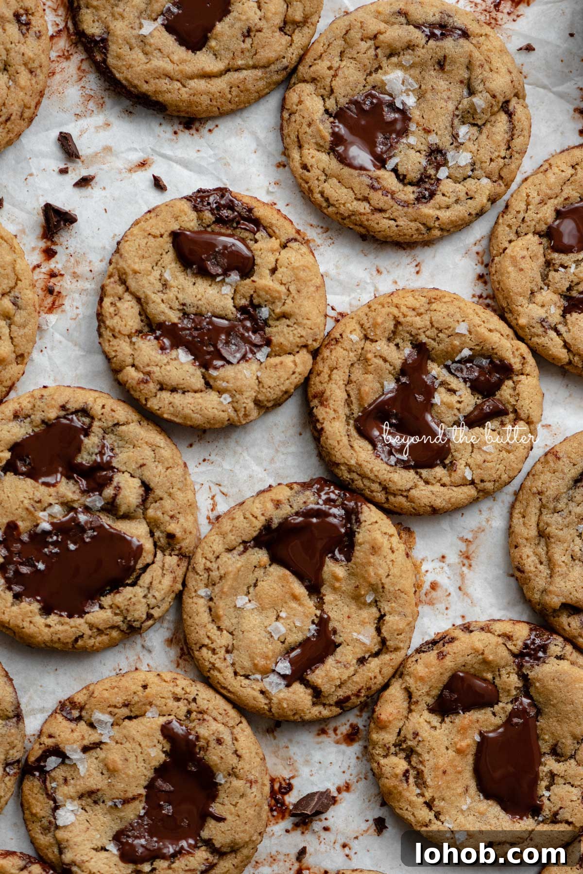 Small batch gluten-free peanut butter chocolate chunk cookies on a parchment paper lined baking sheet | © Beyond the Butter®
