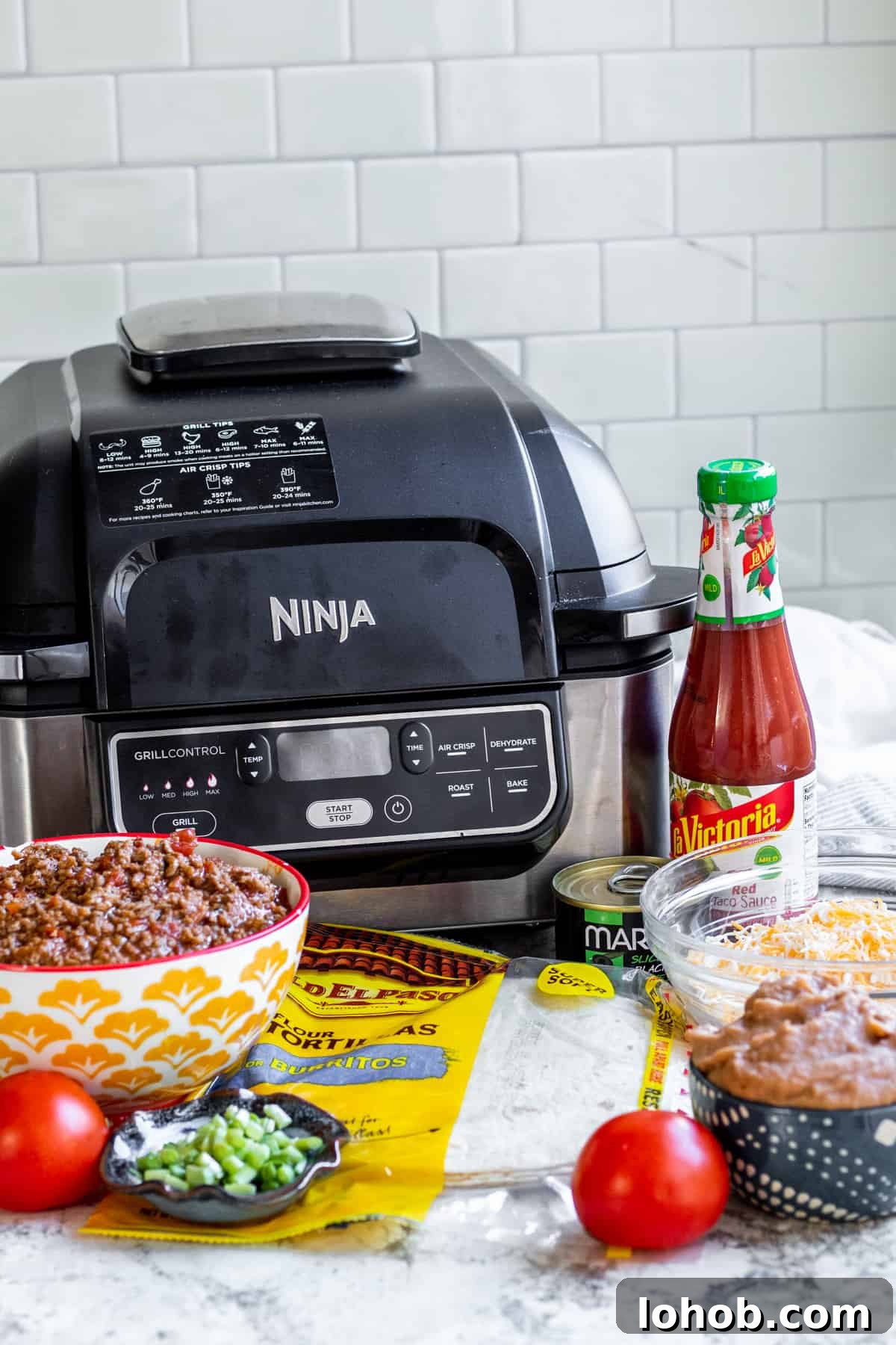 Crispy Air Fryer Mexican Pizza Recipe (30 Minutes) 3 Ingredients for air fryer Mexican pizzas laid out on a white counter in jars and cups.