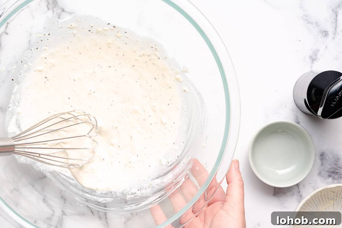 whisking mayo dressing in large bowl