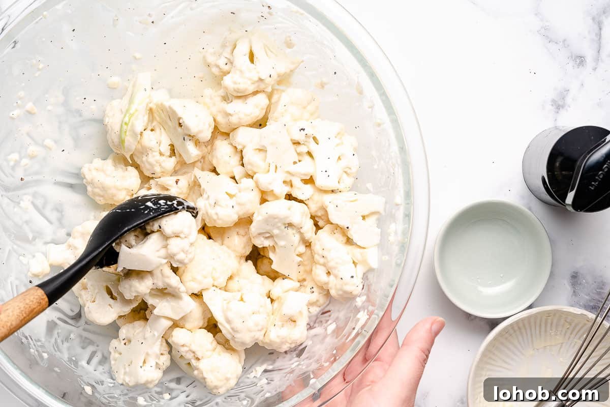 cauliflower florets being stirred with dressing