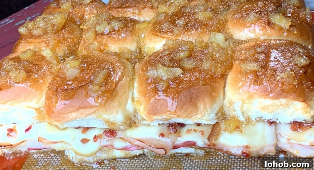 Melted cheese, lunchmeat and bacon on Hawaiian roll sliders with a brown sugar glaze
