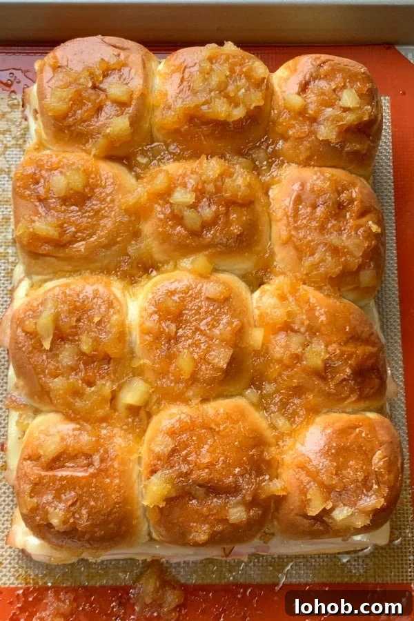 12 Hawaiian roll sliders with sweet pineapple glaze on baking sheet