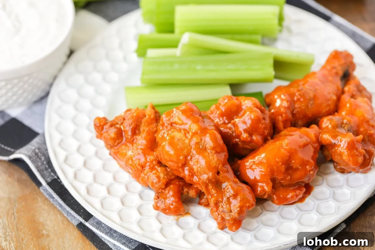 Buffalo wings served on a plate with celery.