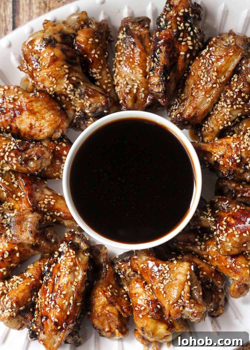 Buffalo wings - a plate of teriyaki chicken wings served with dipping sauce.