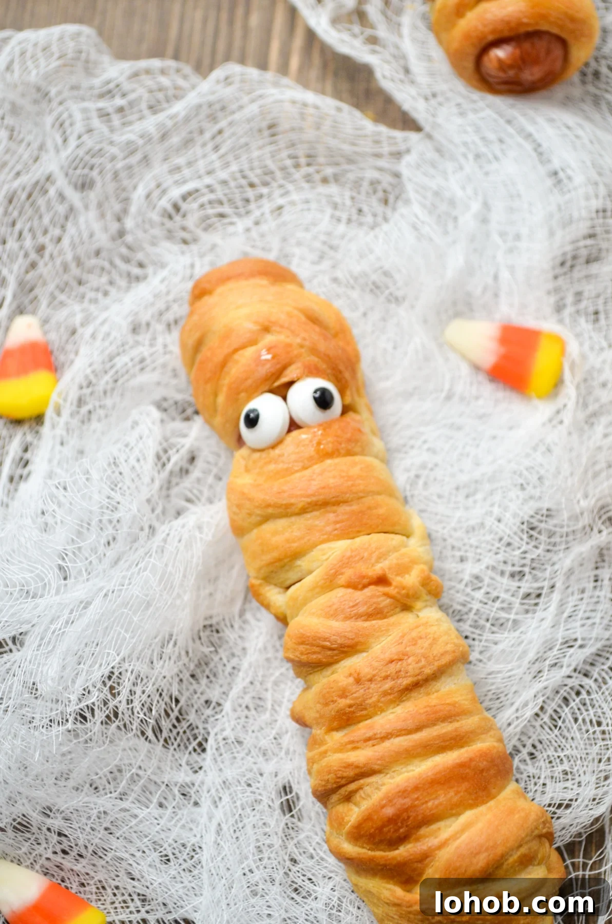 Crispy Mummy Hot Dogs for Halloween – Air Fryer & Oven Guide 9 A hot dog wrapped in crescent roll dough, fitted with candy eyes.