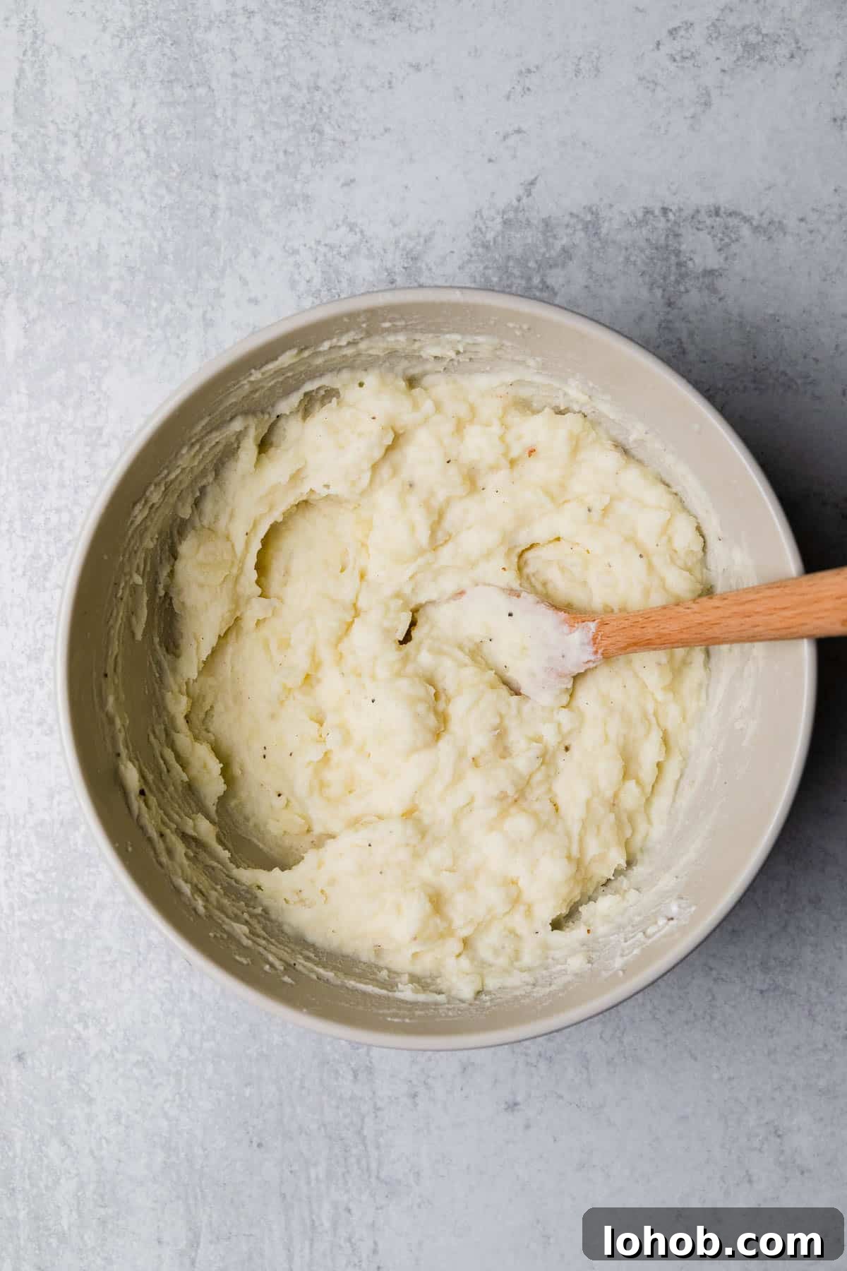 whipping potatoes with a wooden spoon