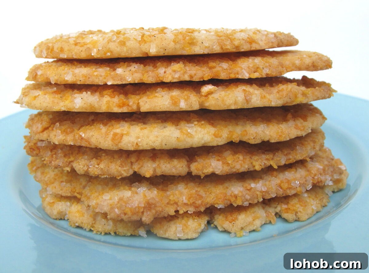 Frosted Flakes Sugar Cookies stacked on blue plate showing thin, crisp edges.