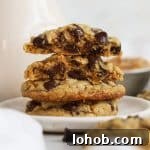 gluten-free peanut butter oatmeal cookies stacked on a white dessert plate next to a bottle of milk