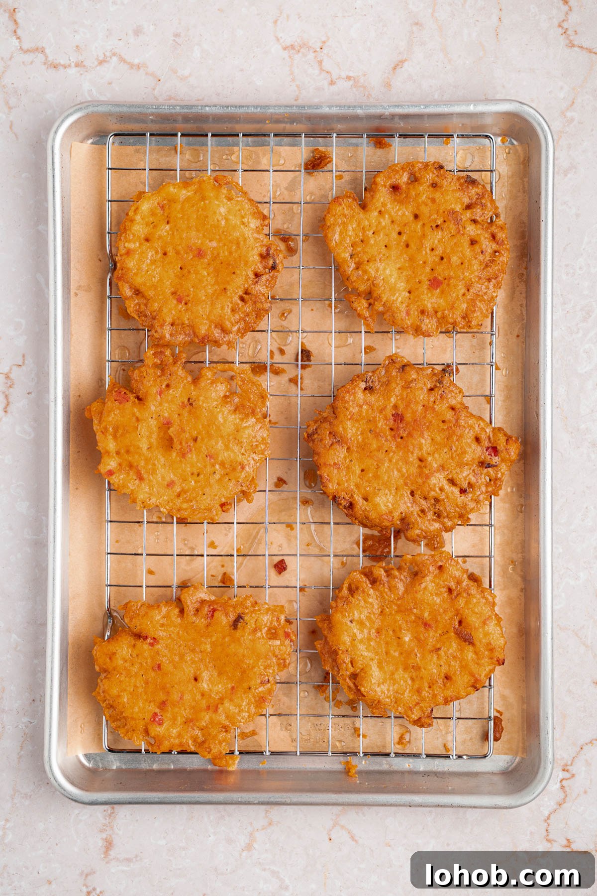 Crispy Bacalaitos: Authentic Puerto Rican Codfish Fritters 7 Six bacalaitos or codfish fritters on a baking rack after frying to drain the oil.