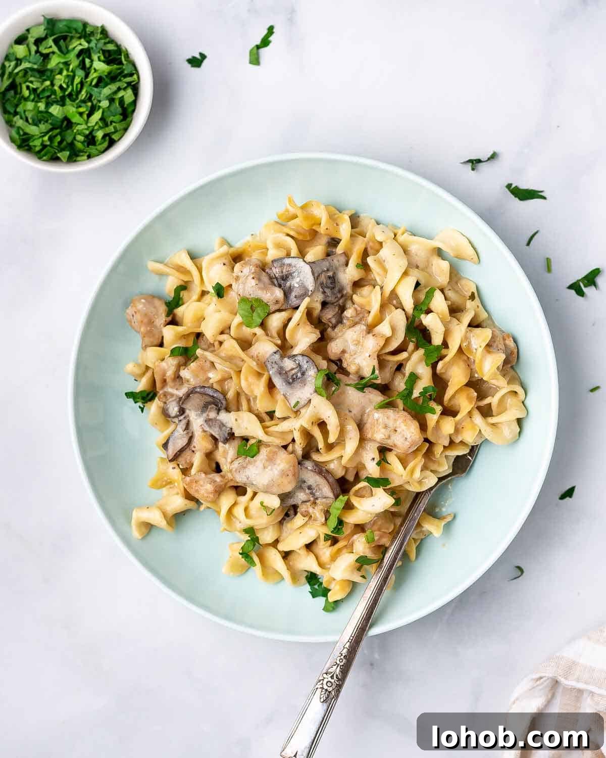 A plate of instant pot chicken stroganoff with a fork in the plate.