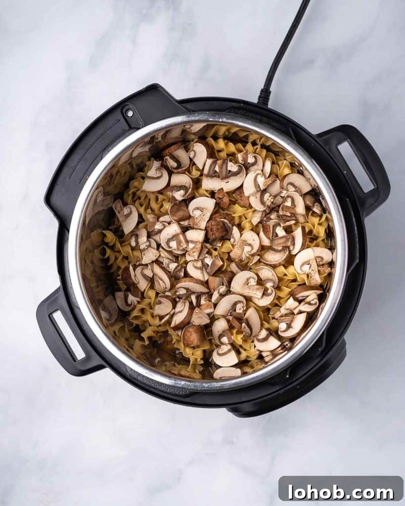 Creamy Instant Pot Chicken Stroganoff Recipe 8 Sliced mushrooms added to the instant pot.