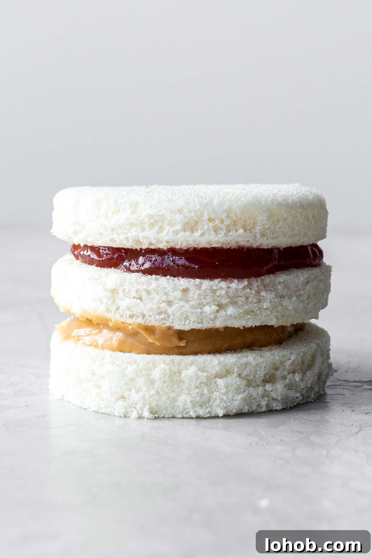 Double-stacked peanut butter and jelly tea sandwich.