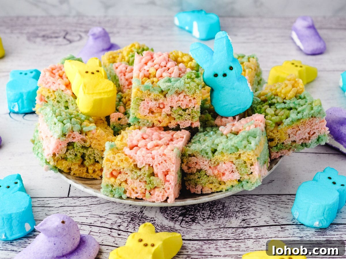 Peeps rice krispie treats on a plate with Peeps on the side.