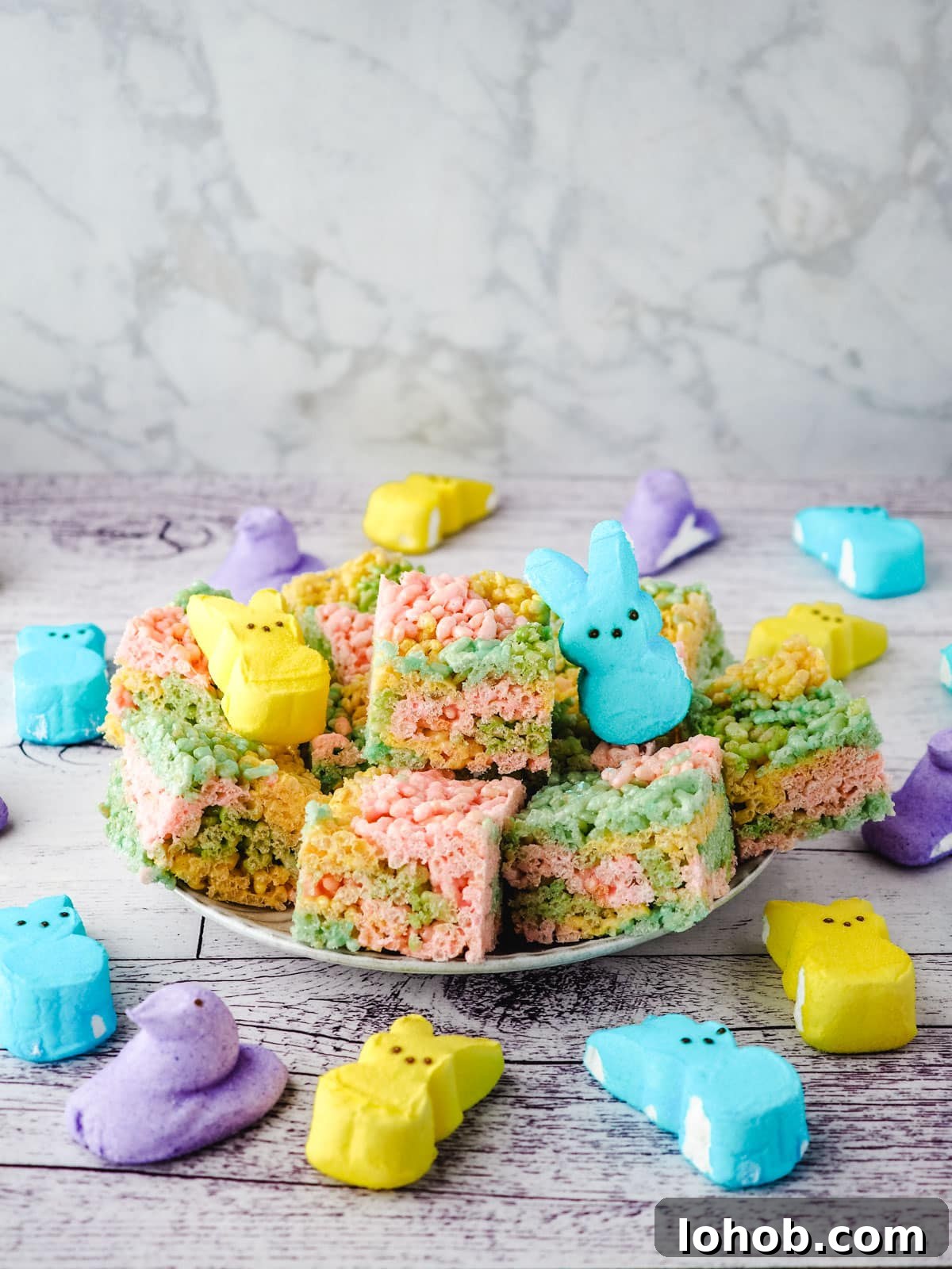 Peeps rice krispie treats on a plate with Peeps on the side.