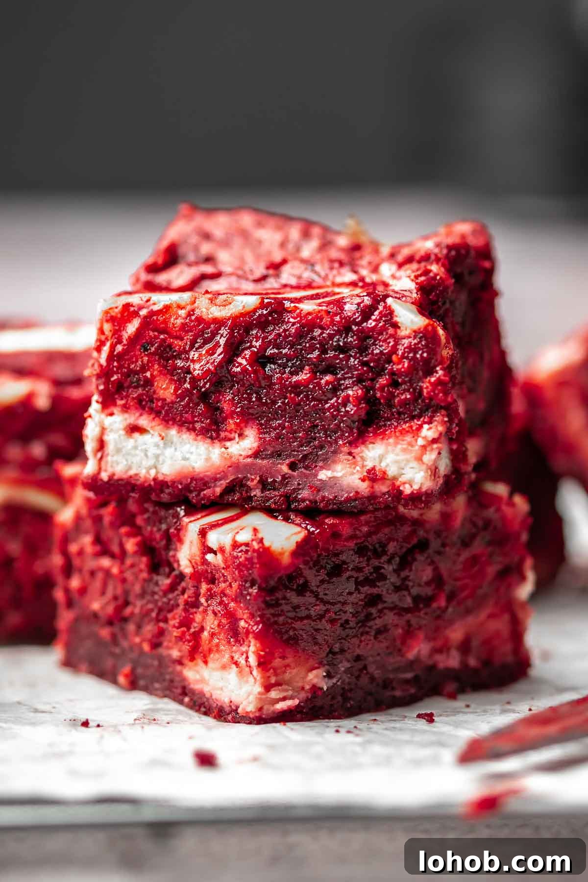 Fudgy Red Velvet Brownies with Cream Cheese Swirl 2 Stack of two red velvet brownies on top of each other.