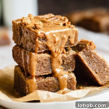 Stack of biscoff blondies with melted cookie butter drizzling over the edge.