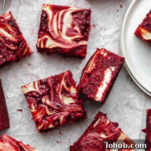 Fudgy Red Velvet Brownies with Cream Cheese Swirl 18 Pieces of red velvet brownies on parchment paper.