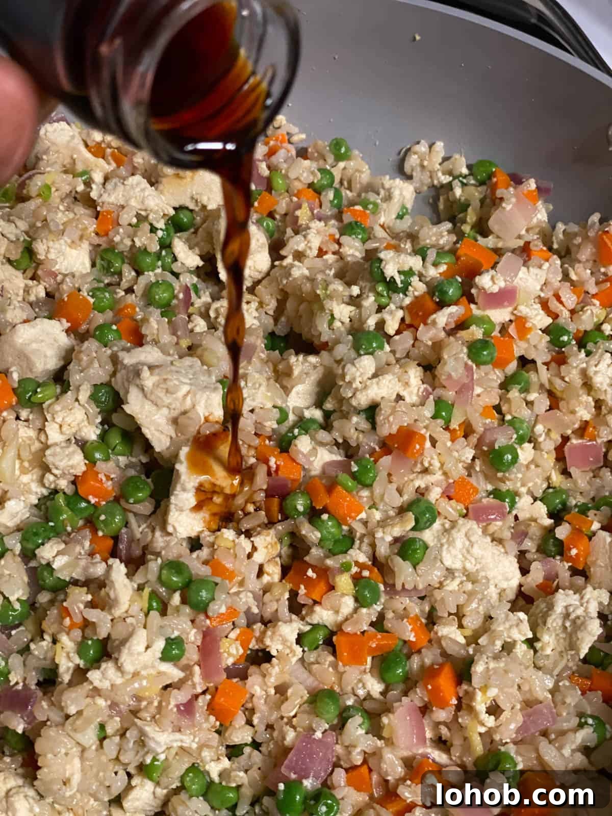 process shot of adding soy sauce to pan