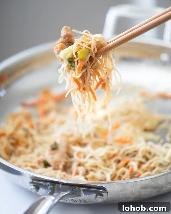 Homestyle Chicken Chow Mein: Quick Takeout-Style Recipe 6 A photo of easy chicken chow mein recipe. Holding the chow mein with chopsticks