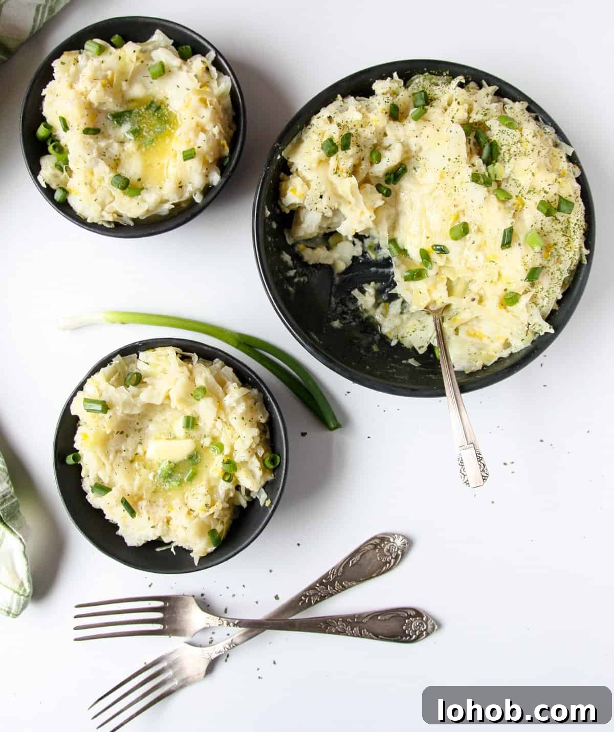 Colcannon: Traditional Irish Mashed Potatoes with Cabbage 3 Irish mashed potatoes being served into individual dishes.