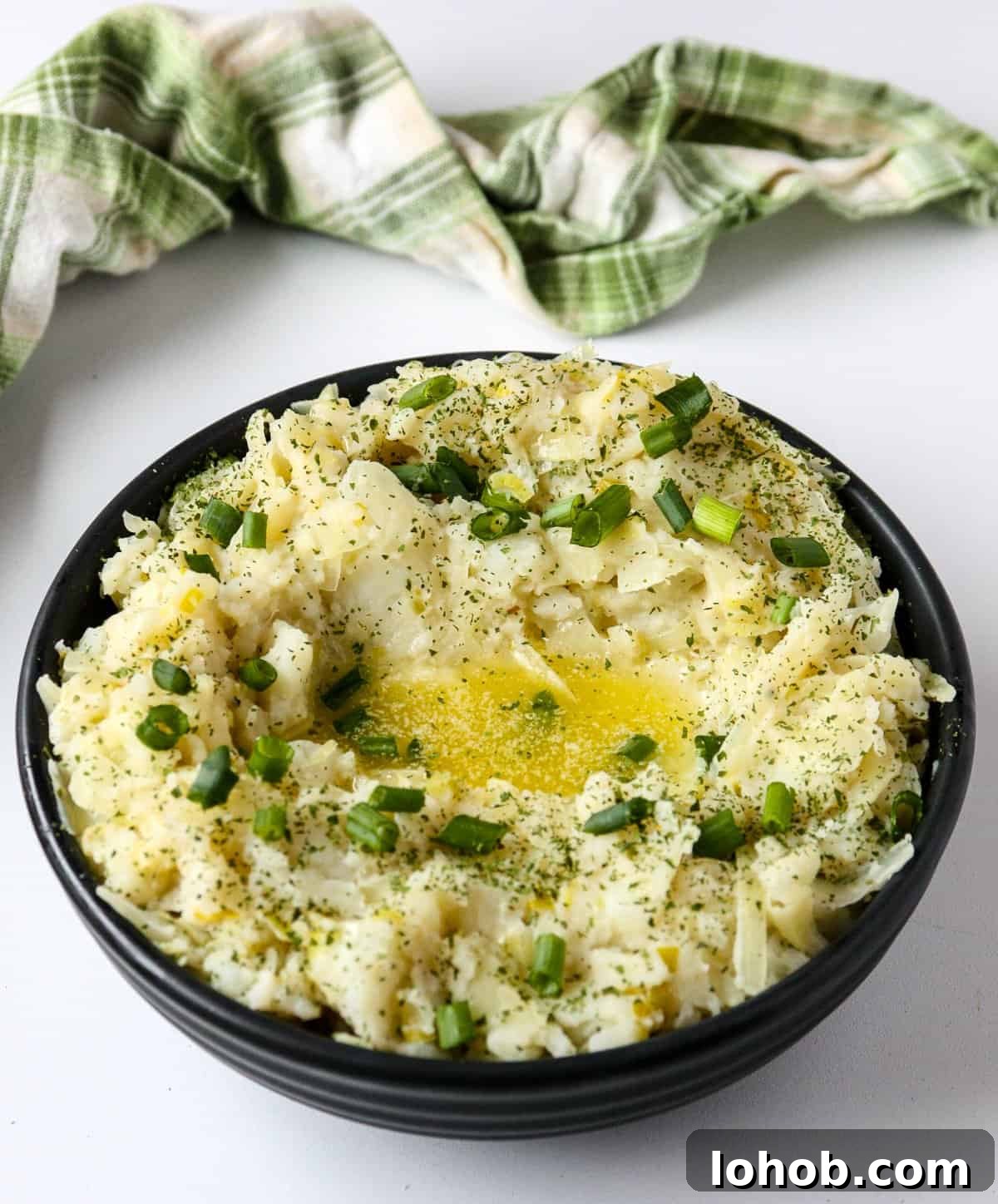 Colcannon: Traditional Irish Mashed Potatoes with Cabbage 6 A bowl of colcannon potatoes topped with melted butter and chopped scallions.