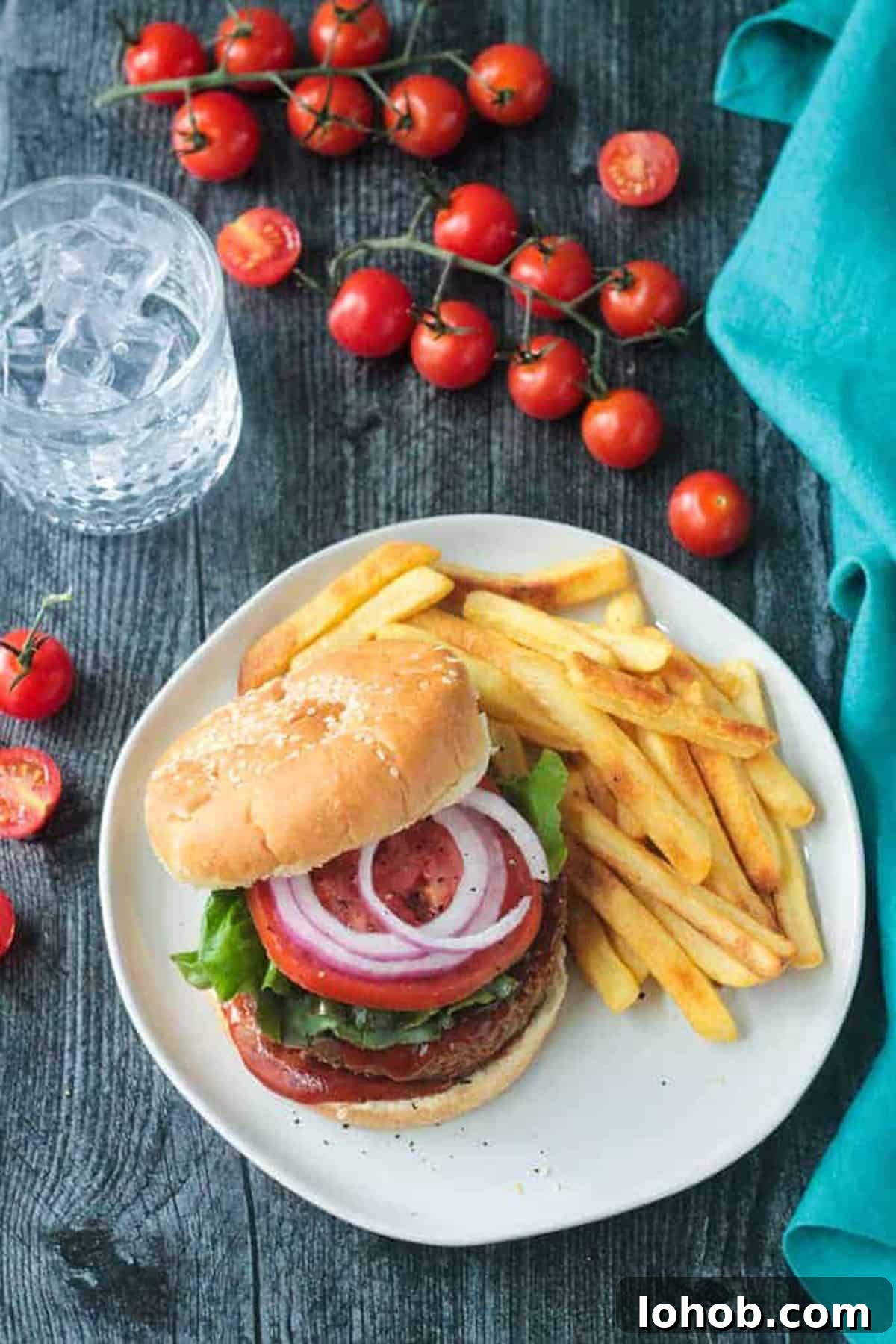 Savory Chickpea Veggie Burger Recipe for Juicy Plant-Based Patties 2 Chickpea veggie burger topped with tomoato and red onion next french fries.