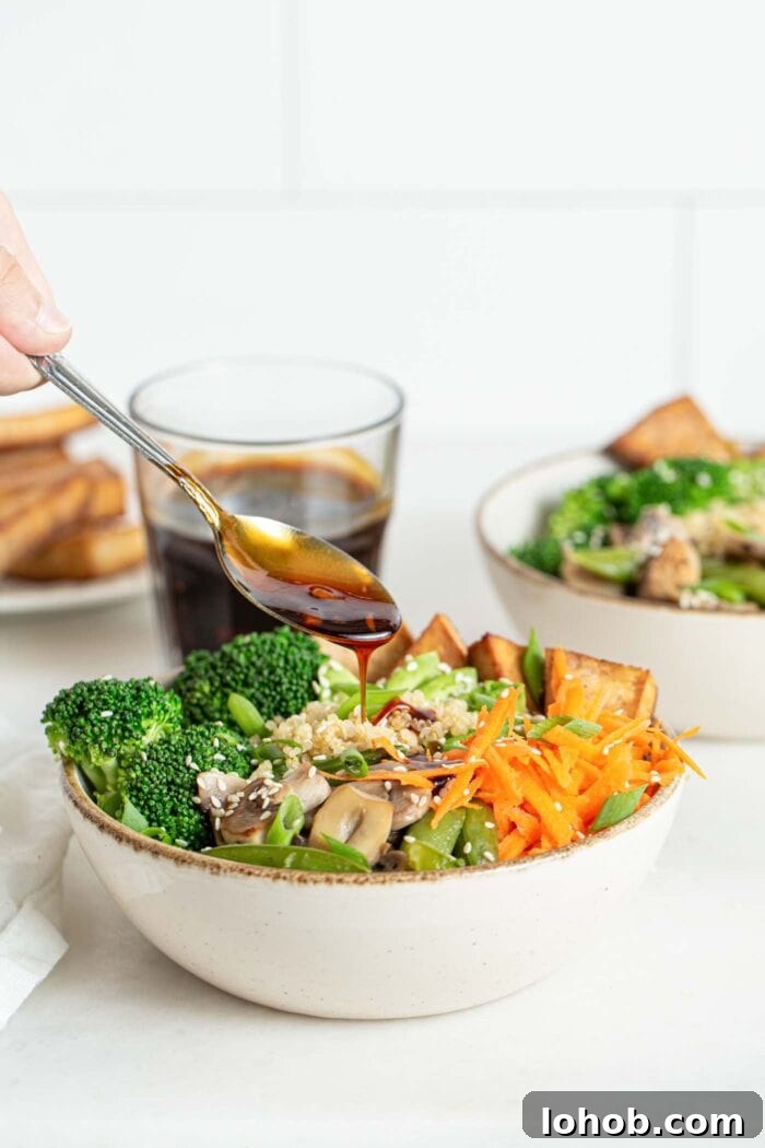 Adding a spoonful of teriyaki sauce to a bowl of stir fried vegetables.