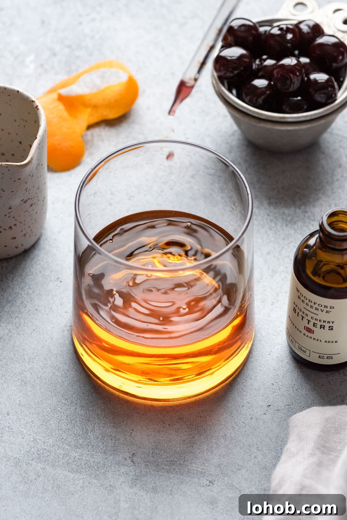 dropping bitters into cocktail