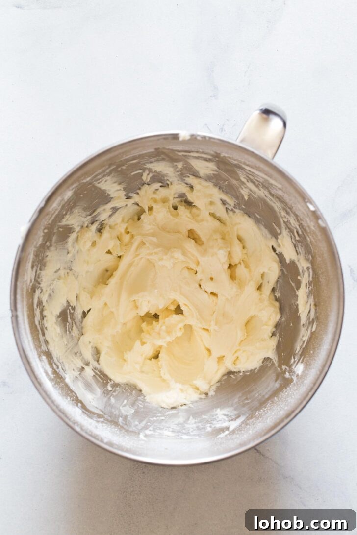 Beating together cream cheese and sugar to make cheesecake filling