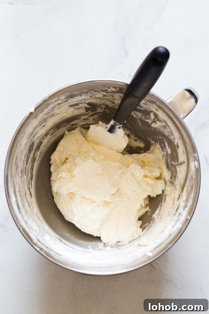 Folding whipped cream into cream cheese mixture for making no bake cheesecake