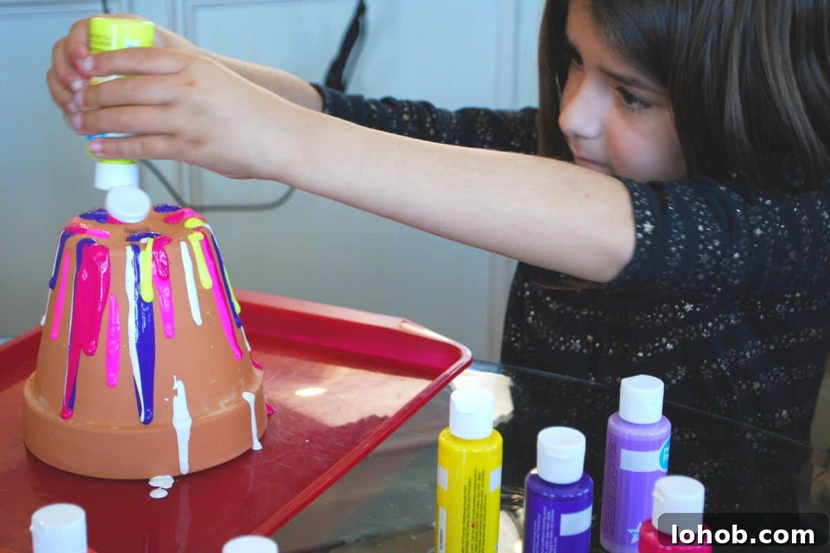 Drip-Painted Flower Pots: Colorful DIY Planter Ideas 5 child squirting paint on flower pot.