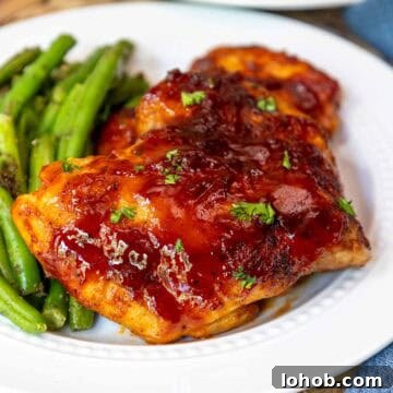 Crispy Oven-Baked BBQ Boneless Chicken Thighs 12 Oven baked BBQ boneless chicken thighs plated with green beans.