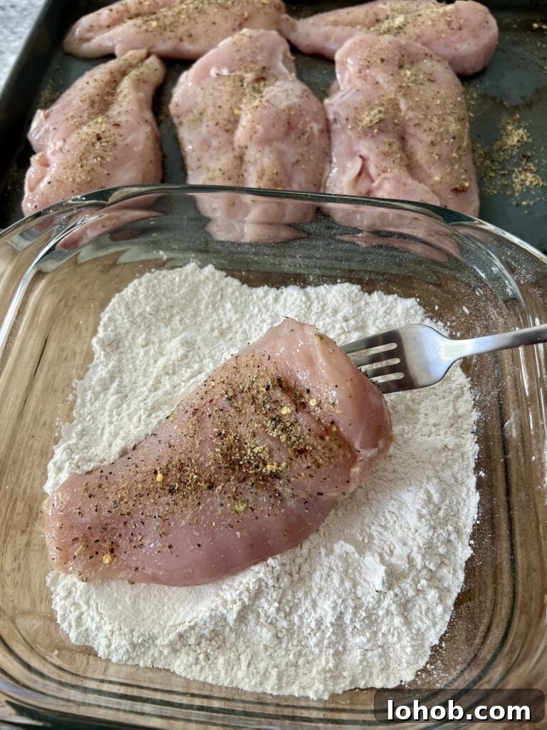 One-Pan Chicken Pomodoro Recipe for Quick Weeknight Dinners 8 Coating one chicken breast in flour using fork.