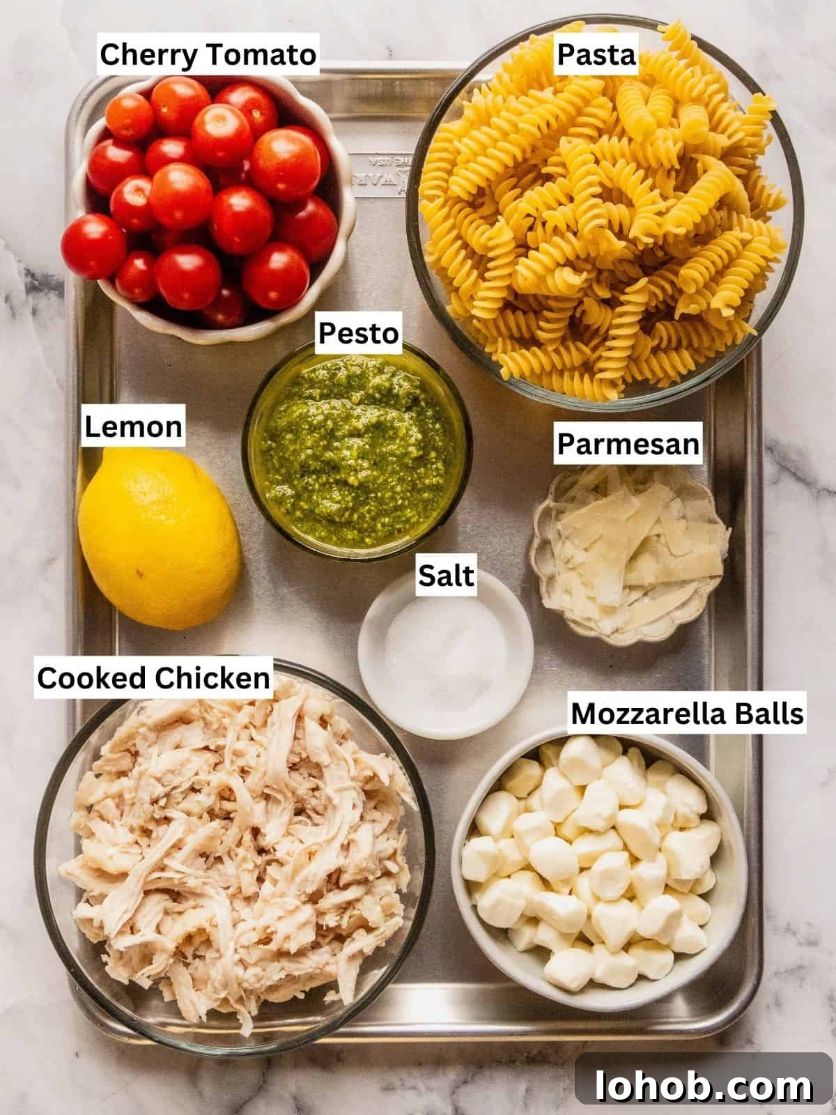 Grilled Chicken Pesto Pasta Salad with Sun-Dried Tomatoes 4 Chicken and pesto pasta salad recipe ingredients with individual labels on a metal tray.