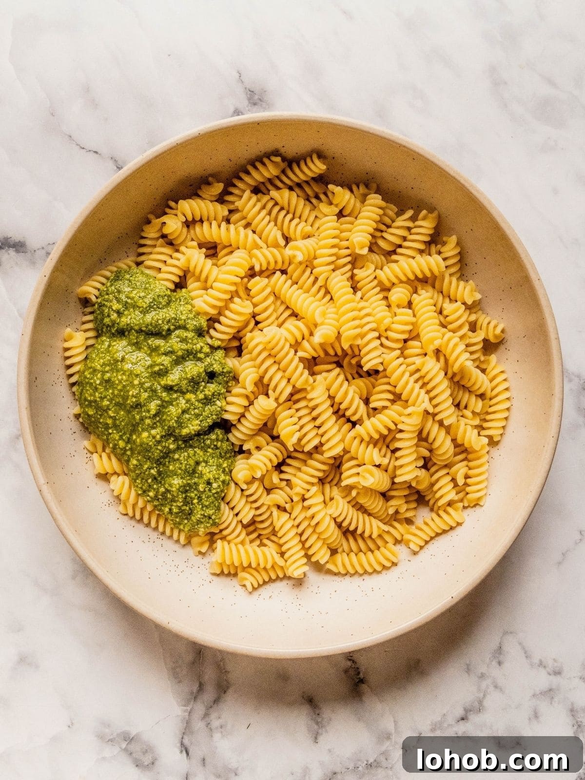 Grilled Chicken Pesto Pasta Salad with Sun-Dried Tomatoes 7 Large bowl with cooked pasta and pesto.