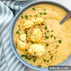 Instant Pot Creamy Cauliflower Soup — Vegan & Low-Calorie 7 A bowl of creamy cauliflower soup topped with roasted cauliflower and fresh parsley.