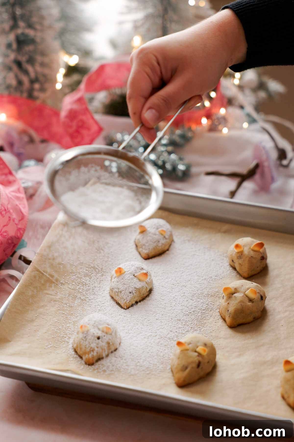dusting baked mouse cookies with powdered sugar